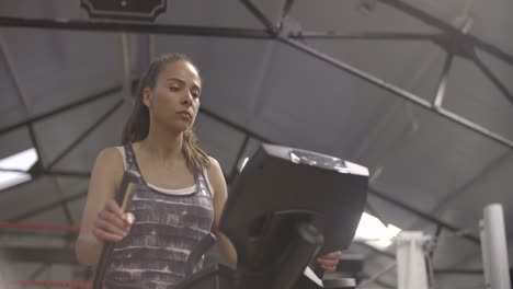 woman using cross trainer in gym