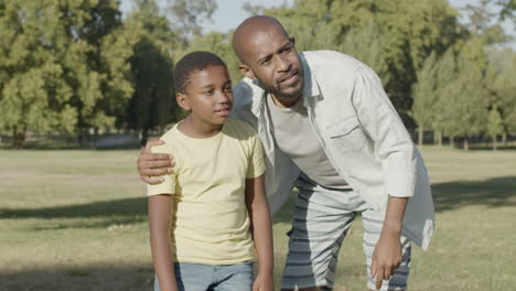 Father-explaining-something-to-his-son-while-walking-in-park.