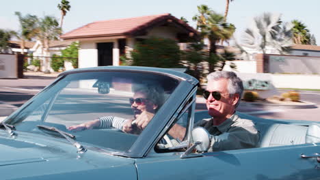 senior white couple on the road in a convertible, close up