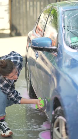 woman washing a blue car