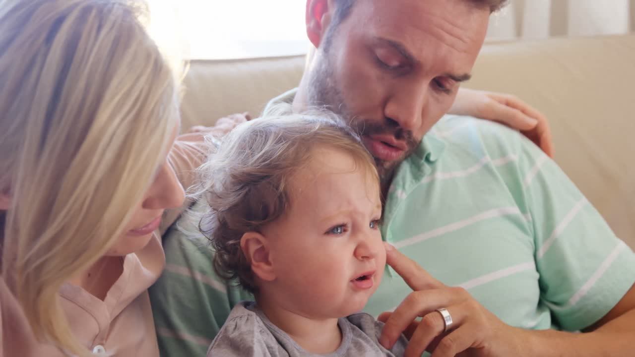 아기 가 어머니 와 아버지 사이 에 앉아 있다