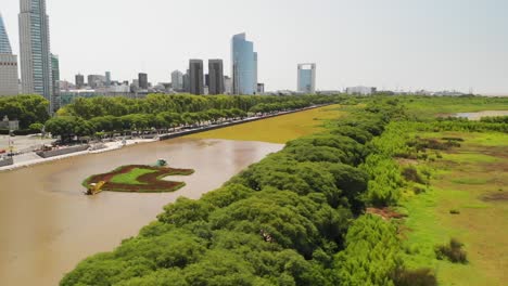 moving aerial view of the buenos aires reserve wetland with the city on the horizon