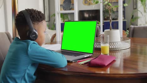 African-american-boy-using-laptop-for-video-call,-with-copy-space-on-screen