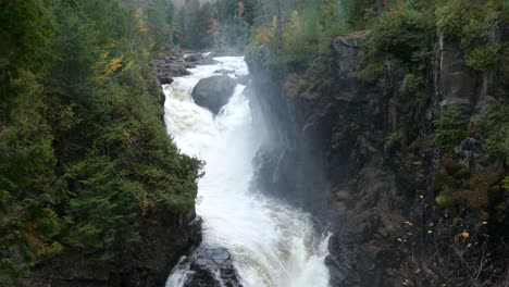 slow tilt down shot of absolutely gorgeous waterfall with heavy flow of water