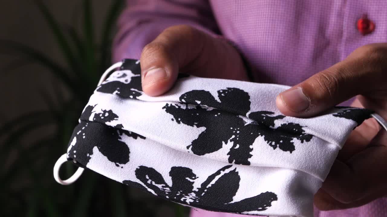 persona que sostiene una máscara facial con impresión floral