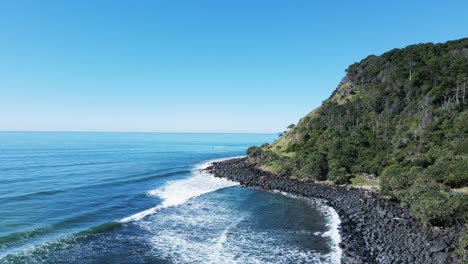 waves roll in on the world famous burleigh heads surf break and iconic headland