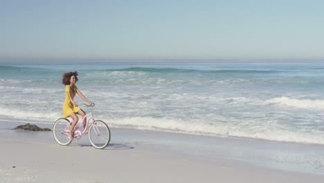 Afroamerikanische-Frau,-Die-Am-Meer-Fahrrad-Fährt