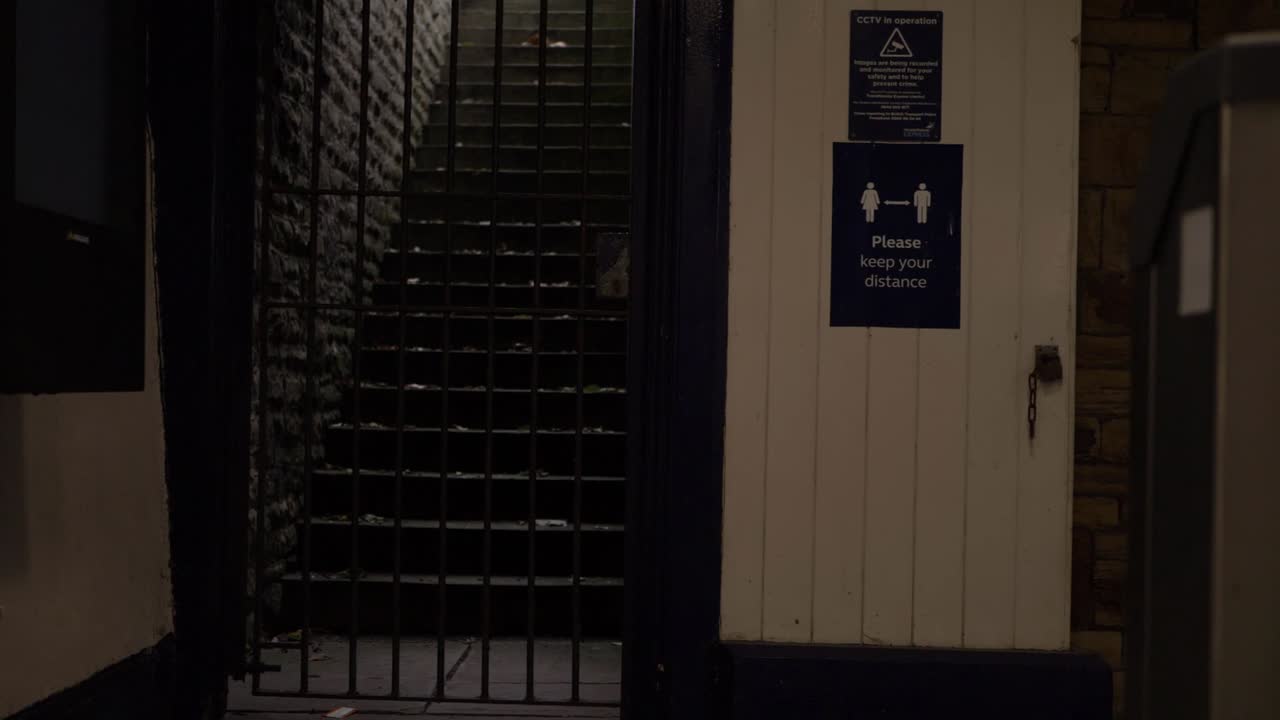 Walking through lonely dark train station exit and ticket machines