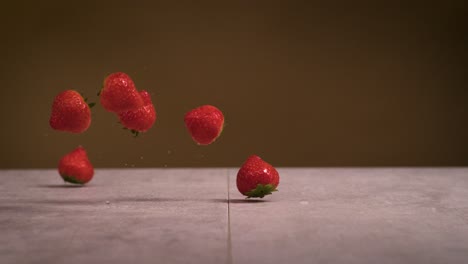 Fresas-Cayendo-Sobre-Una-Superficie-De-Piedra-Con-Fondo-Marrón-En-Cámara-Súper-Lenta