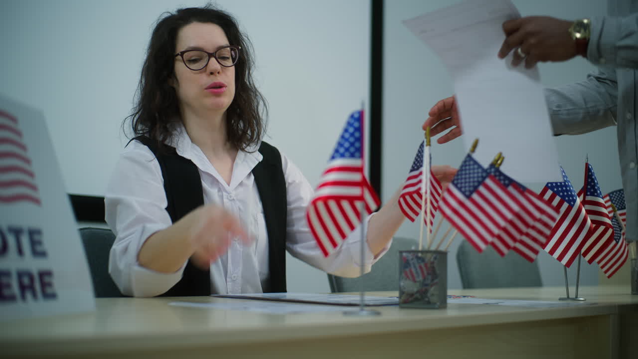 African American Male Voter Talks with Female Polling Officer African American Man Takes Paper Ballot for Voting at Polling Station Male Voter Talks with Female Polling Officer National Election Day in the United States of America Civic Duty and Democracy