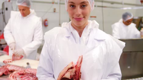 Portrait-of-female-butcher-holding-raw-meat