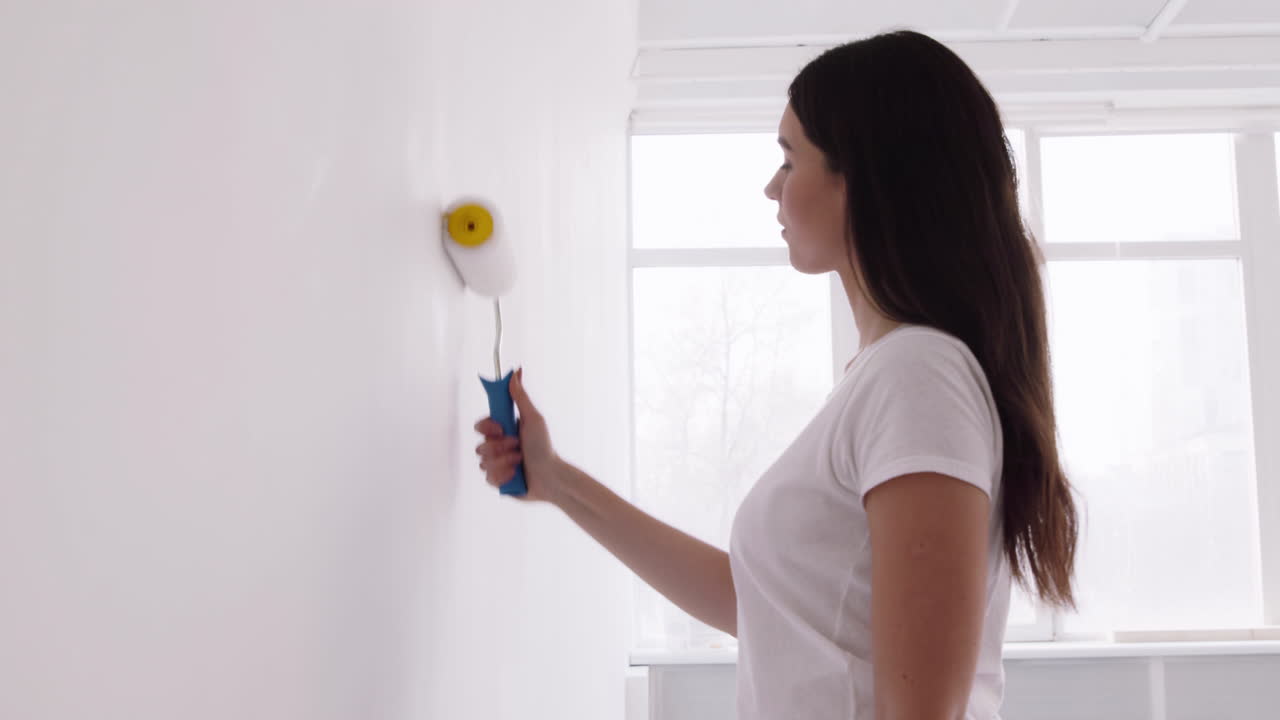 Una mujer pintando una pared.