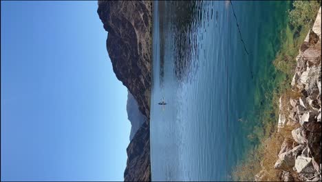 Vertikale-Aufnahme-Einer-Kajakfahrt-Auf-Dem-Colorado-River-Mit-Bergen-Im-Hintergrund