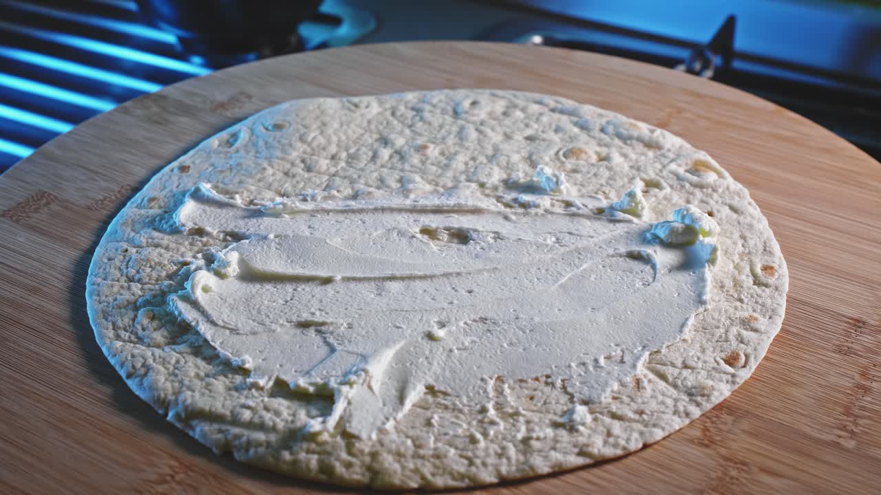 unte queso bajo en grasa y mayonesa sobre una envoltura de tortilla integral, luego rellene con chili con carne y enrolle