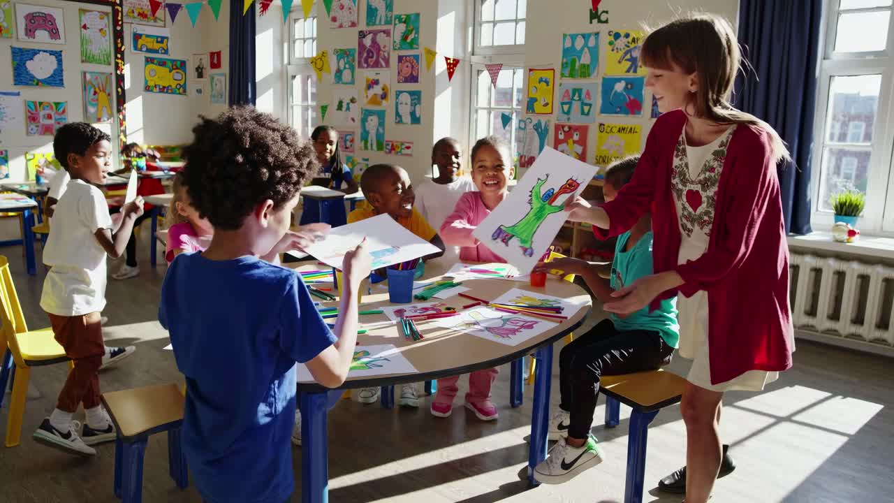 Escena de video de aula luminosa con niños dibujando en mesas redondas