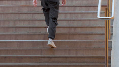 a person is ascending outdoor steps, captured mid-stride, focusing on the lower half of the body