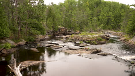 El-Agua-Fluye-Suavemente-Por-Un-Río-Panorámico-En-Un-Entorno-Natural-Prístino