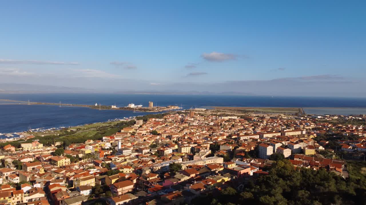 Establishing aerial drone view of Sant'Antioco small town towscape, sideways