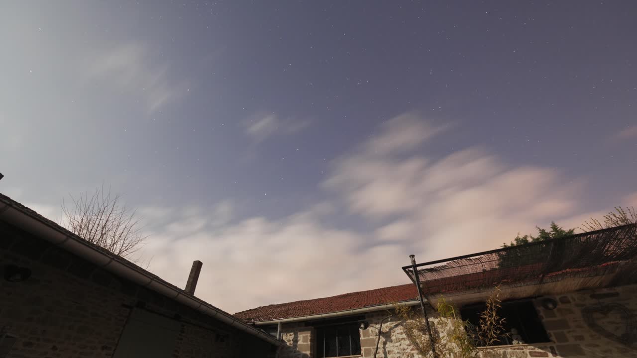 달이 뜨는 동안 오래된 벽돌 건물 위에 구름진 밤 하늘 시간 경과