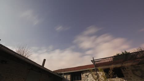 Cloudy-night-sky-time-lapse-above-old-brick-buildings-as-moon-rises