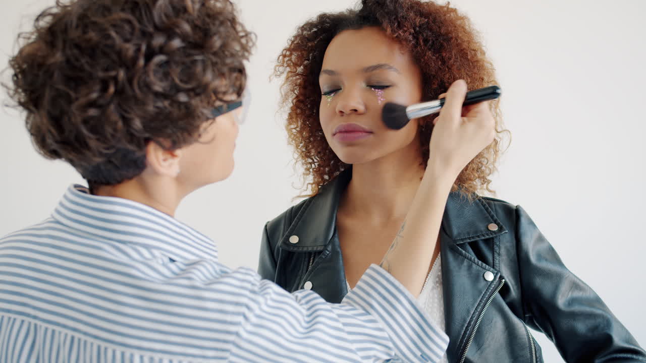 artista de maquillaje aplicando maquillaje a un modelo