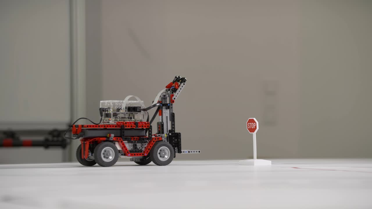 A self-driving line-following robot from a student project drives over the drawn lines of a street map and reacts to a stop sign