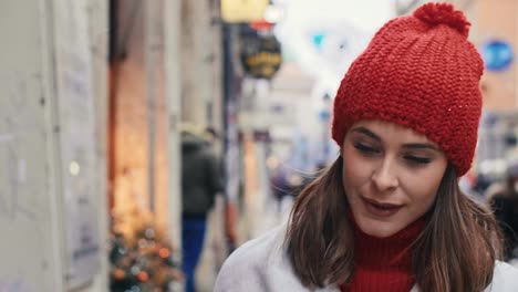 mujer hermosa mirando en la ventana de la tienda durante las compras de navidad