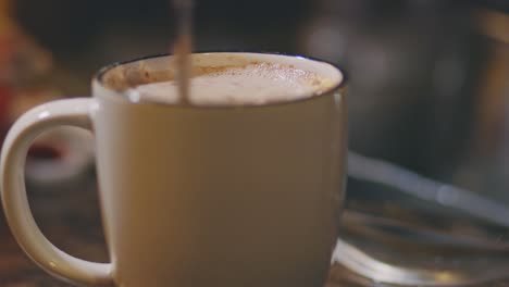 stirring hot choco in a cup with a teaspoon - close up