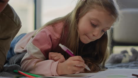 cute girl coloring picture with pencils. sister drawing next to brother indoors.