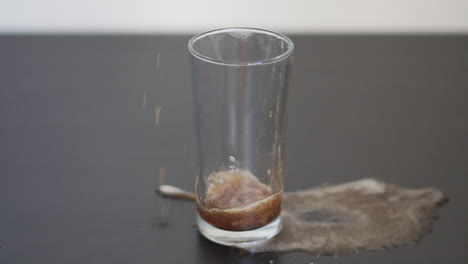 slow motion video of a man filling a glass with soda and causing a spillage