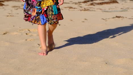 Young girl in pretty skirt walking along beach