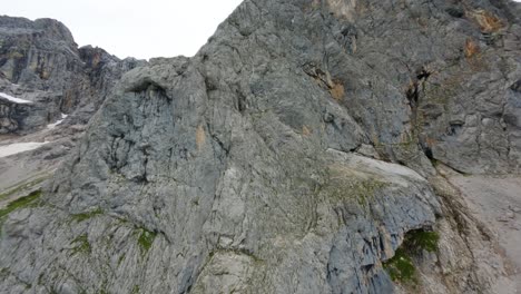 FPV-drone-flight-approaching-a-steep-gray-mountain-wall-of-Dachstein-in-Austria