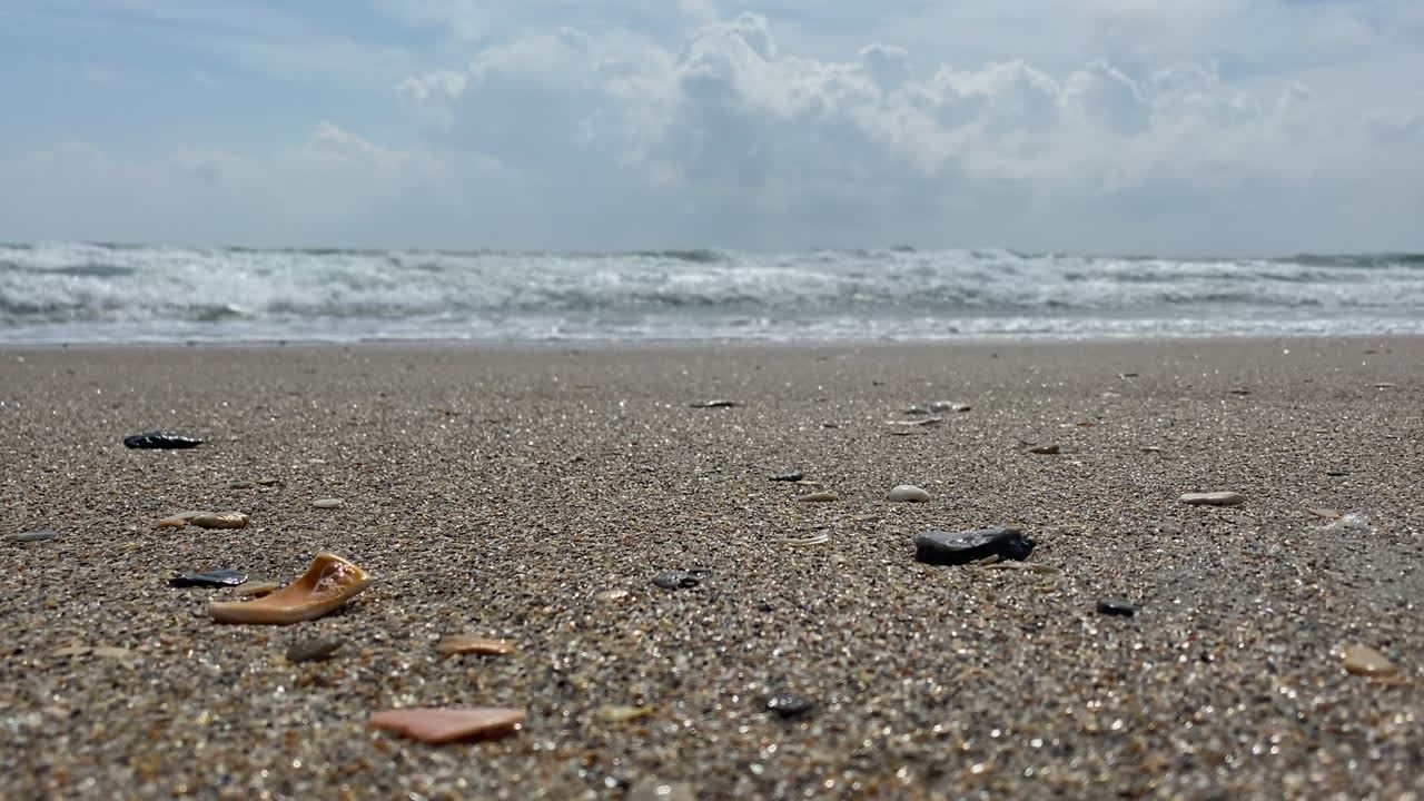 일몰 동안 바위가 많은 해안선으로 굴러가는 해일