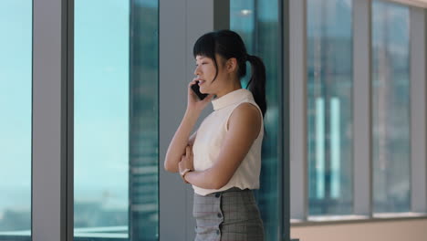 asian-business-woman-using-smartphone-corporate-sales-executive-chatting-to-client-financial-advisor-negotiating-deal-sharing-expert-advice-having-phone-call-in-office-looking-out-window