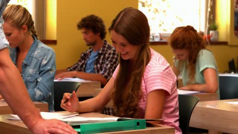 happy student being helped by teacher in the classroom