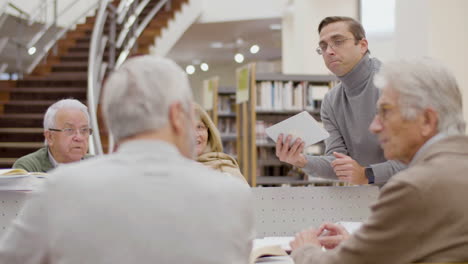 focused teacher listening senior peoples answers during class