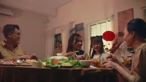 family enjoying a meal together, with a young child playfully interacting