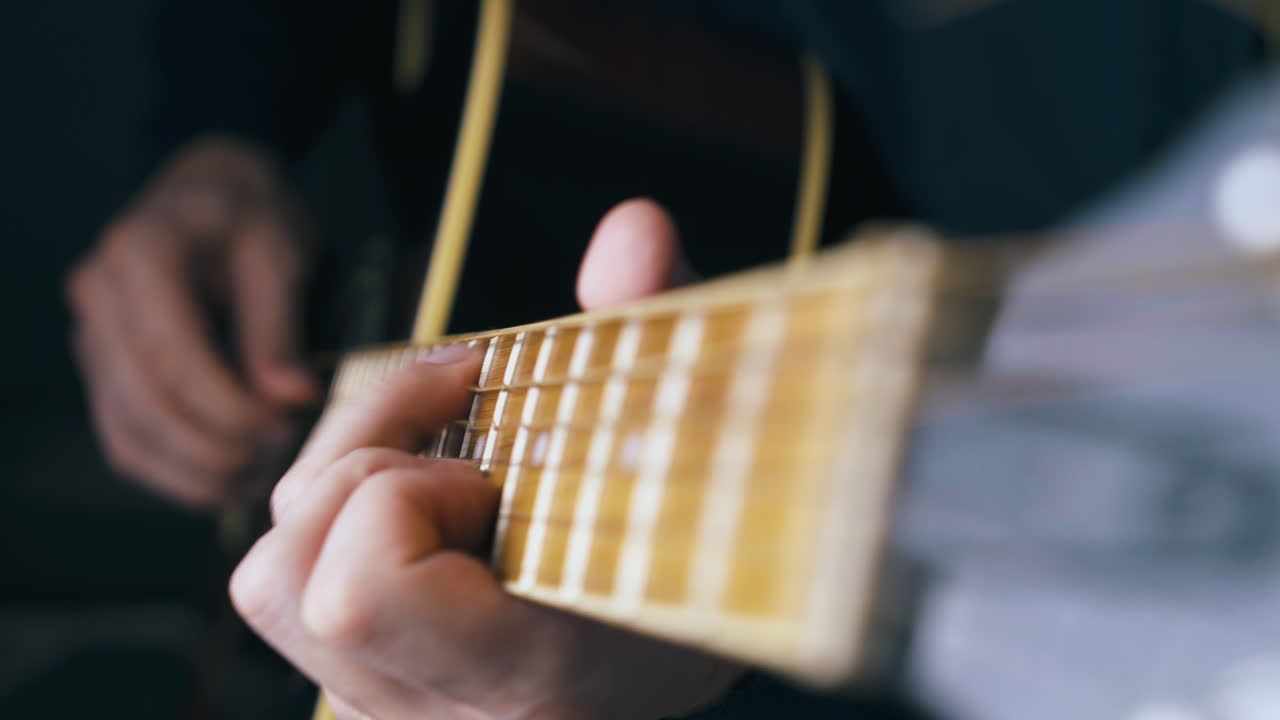 skilled guitarist strikes various chords on acoustic guitar