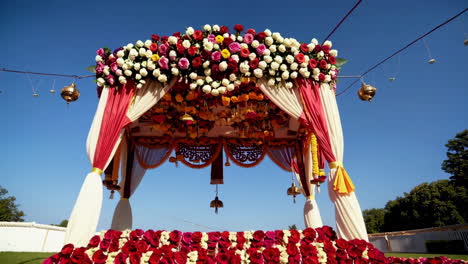 beautifully decorated indian wedding canopy with vibrant flowers under a clear blue sky