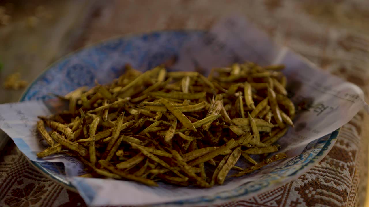 A plate of fried Kandi a traditional Sindhi food is presented on a blue plate in Tharparkar Sindh. This local delicacy is often served as a snack or side dish in Pakistani
