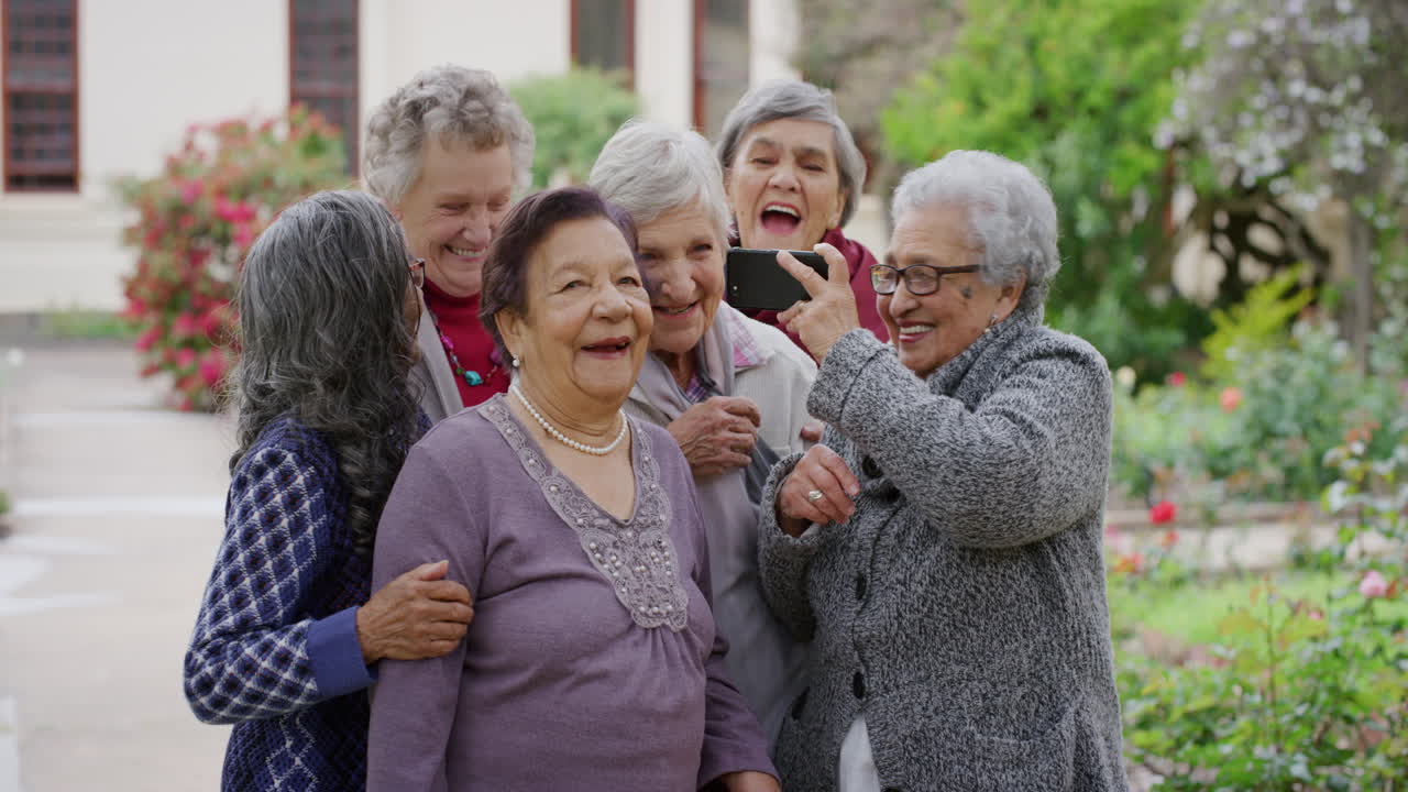 grupo de mujeres de edad avanzada diversas que usan teléfonos inteligentes tomando fotos selfie riendo alegres disfrutando de un estilo de vida de jubilación despreocupado en un hermoso jardín al aire libre