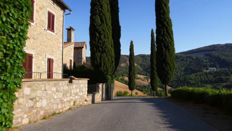 scenic tuscan countryside road with cypress trees and stone villa