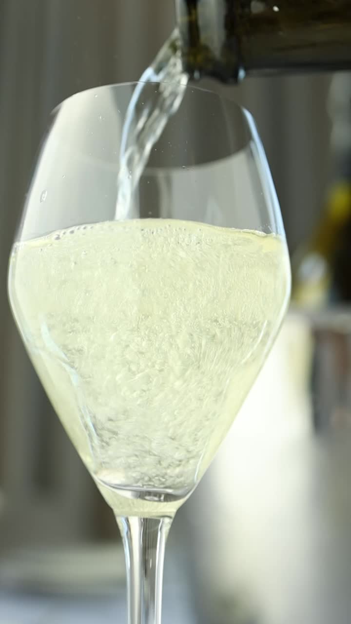 Versare il vino bianco in un bicchiere