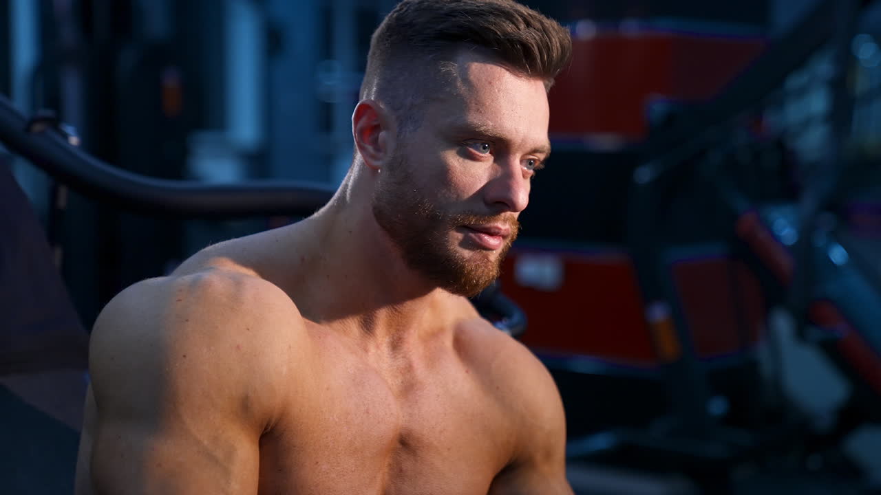 Muscular man in gym. Fit and sporty bodybuilder man in gym