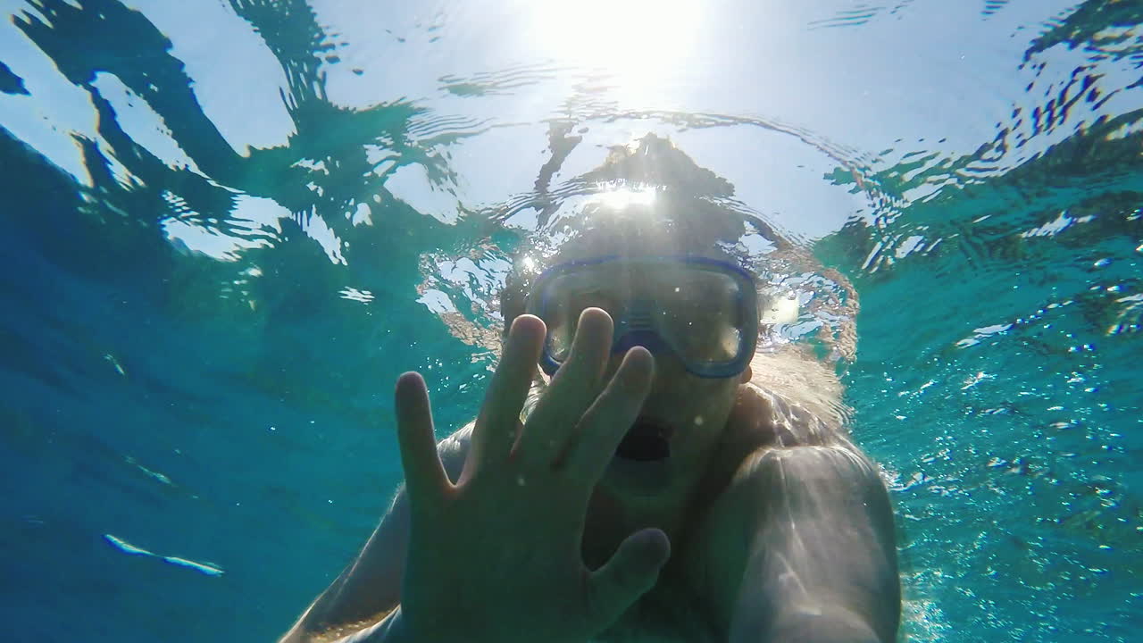 카메라를 향해 손을 흔드는 다이버 - 수중