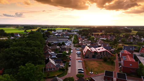 flight above the lovely town with lush greenery. sunset view of the residential area under the orange sky