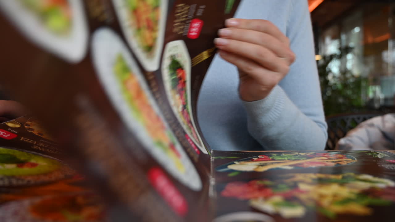 Kvinde der læser et menukort på en restaurant under en forretningsfrokost