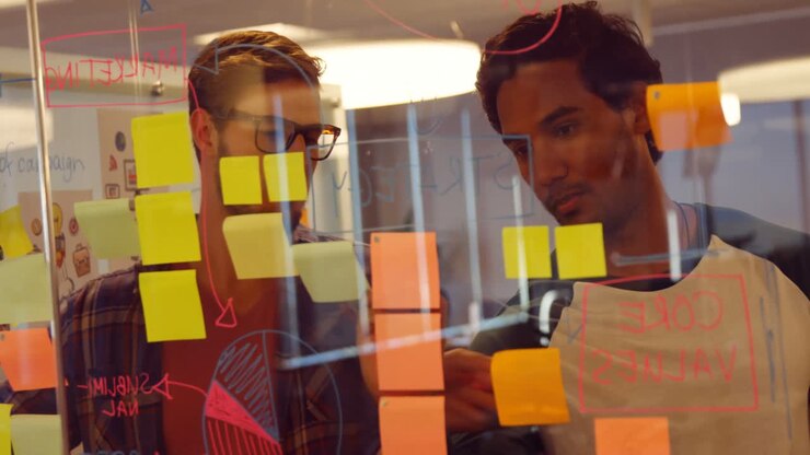 Business colleagues discussing over sticky notes