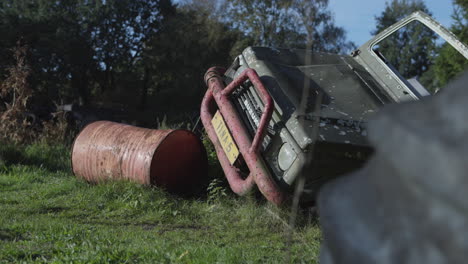 Abandoned-rusty-car-on-its-side,-left-in-field