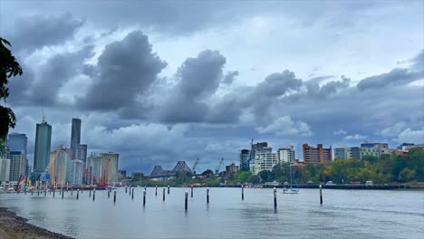 vistas muy dramáticas y cinematográficas sobre el puerto deportivo del río brisbane hacia el puente de la historia en el centro de brisbane, australia, con nubes de tormenta amenazantes que se construyen en lo alto